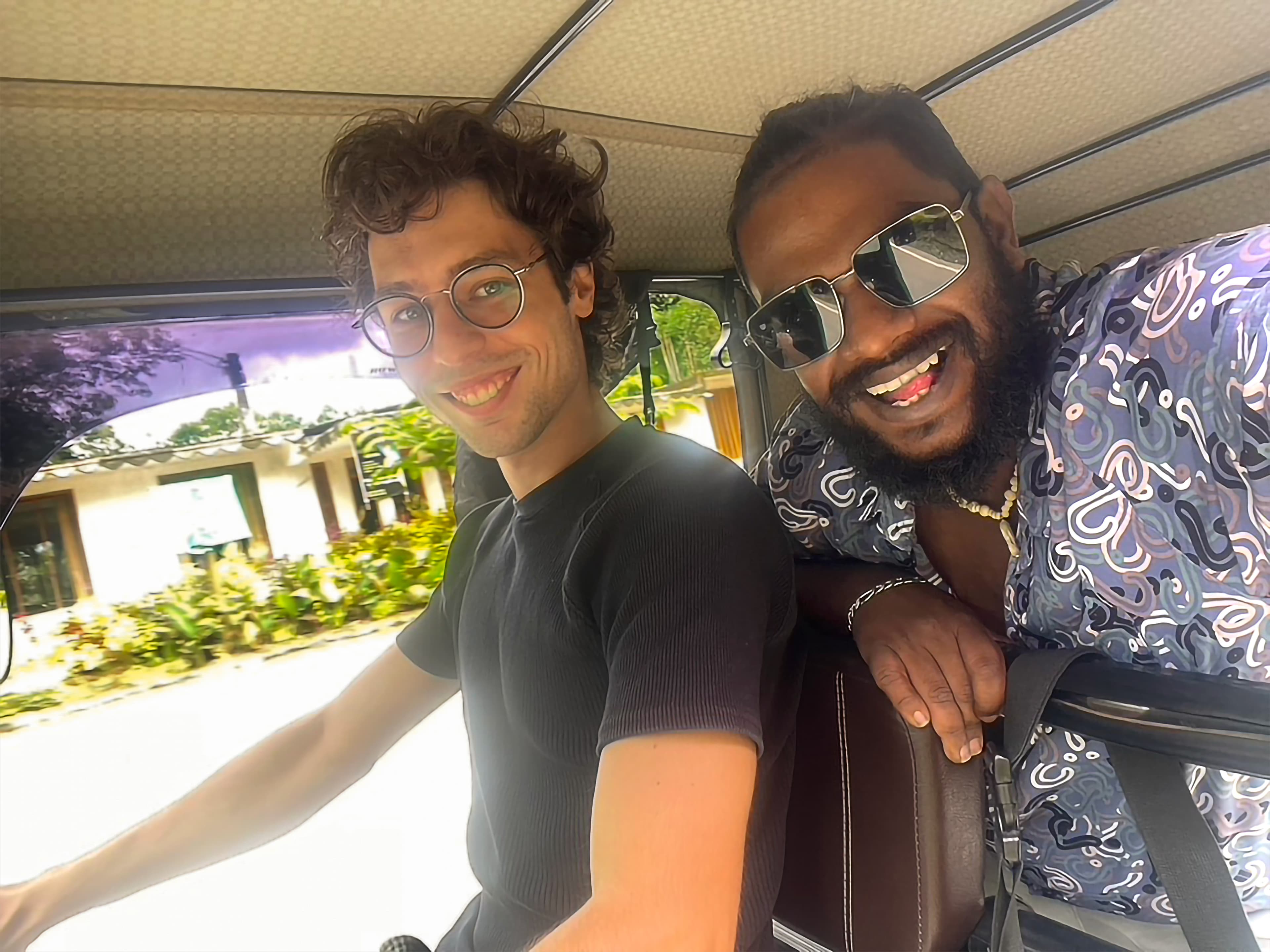 Founders of Triptuk smiling inside a tuk tuk